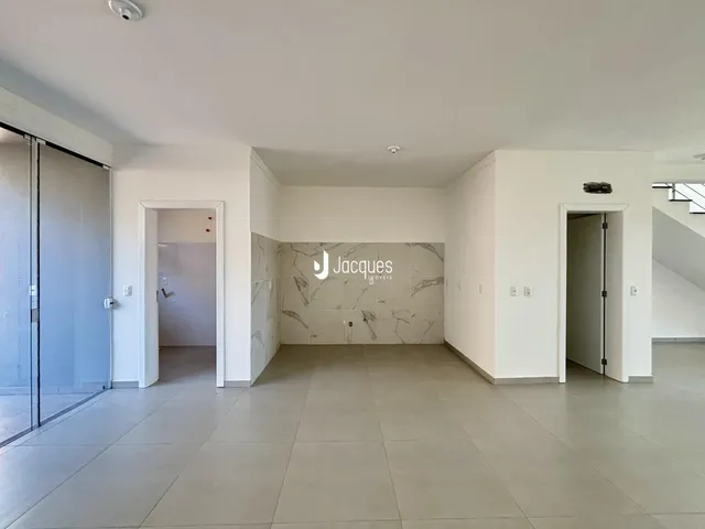 Hall de entrada com piso de cerâmica cinza claro e paredes brancas.