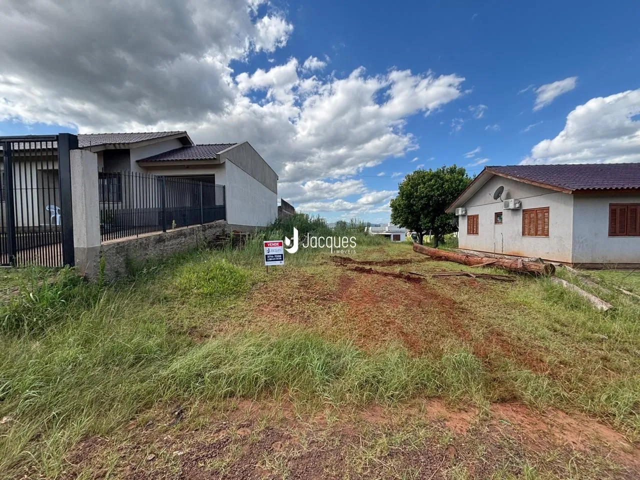 Vista externa de duas casas em terreno com vegetação na frente.