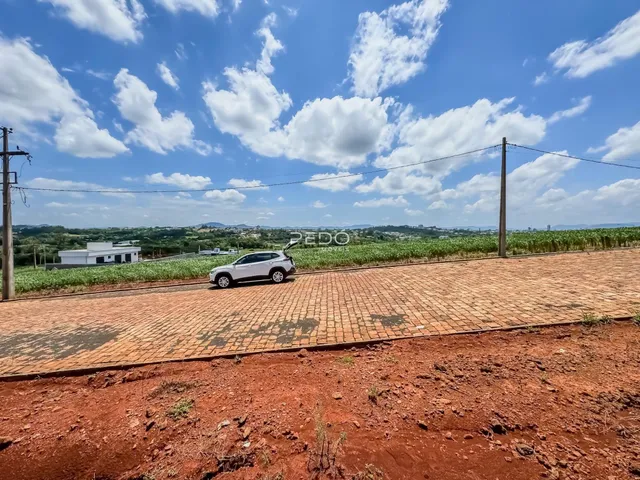 Vista da propriedade com estrada e campo ao fundo.