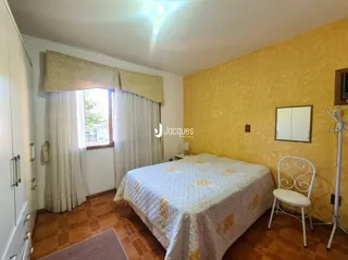 Quarto com cama e cortinas em uma sala.