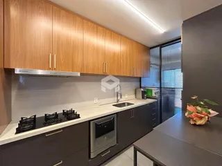 Cozinha moderna com armários de madeira e bancada clara.