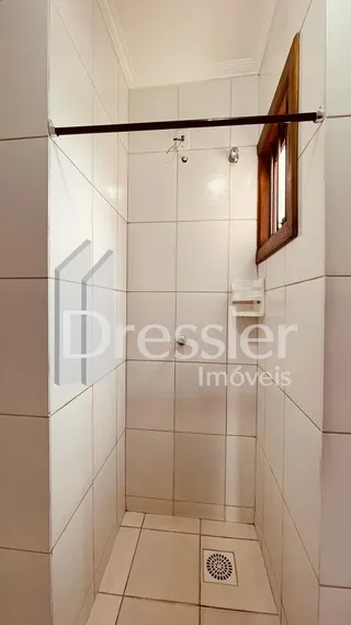 Corredor interno com paredes brancas e piso de cerâmica