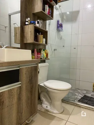 Foto de um banheiro com azulejos brancos e louças sanitárias.