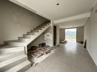 Vista interna de um espaço amplo com escadaria e piso de concreto em Lajeado.