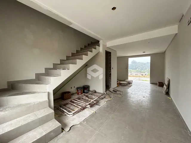 Vista interna de um espaço amplo com escadaria e piso de concreto em Lajeado.
