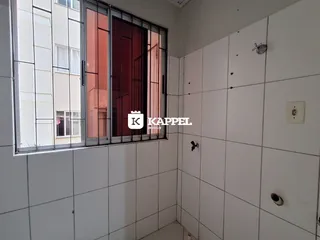 Hall de entrada com paredes brancas e grandes janelas de caixilho.