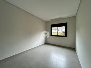 Uma sala interna com paredes brancas e piso de cerâmica.