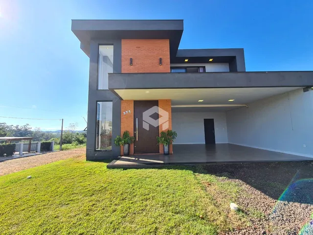 Fachada moderna de uma casa em Lajeado, Brasil, com jardim gramado na frente.