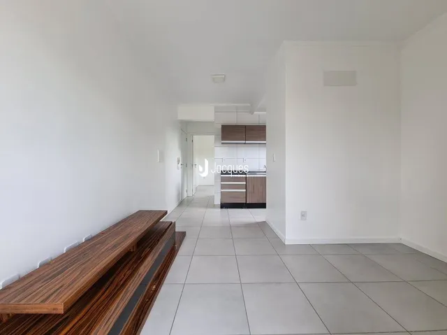 Interior de um espaço com paredes brancas e piso de cerâmica.
