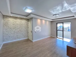 Sala de estar com piso de madeira clara e parede texturizada em um imóvel no Brasil.