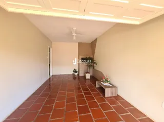 Corredor interno com piso de tijolos vermelhos.