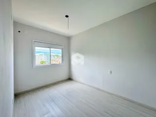 Sala de estar com piso de madeira clara e janela de vista.