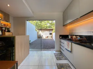 A cozinha e a área de jantar se abrem para um pátio externo.