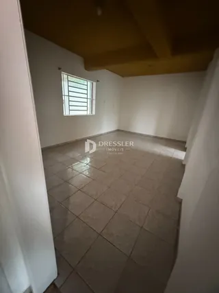 Vista interna de um cômodo com piso de cerâmica e janela.