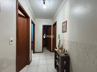 Hall de entrada com portas de madeira e piso cerâmico.