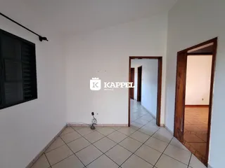 Vista interna de um ambiente com piso de cerâmica clara e paredes brancas.