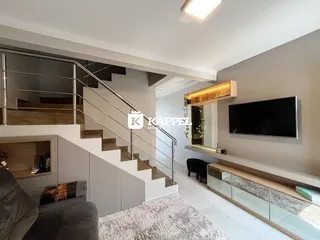 Sala de estar moderna com escadaria e painel de televisão em um apartamento.