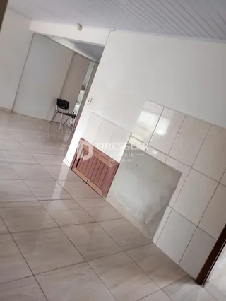 Hall de entrada com piso de cerâmica clara e paredes brancas.