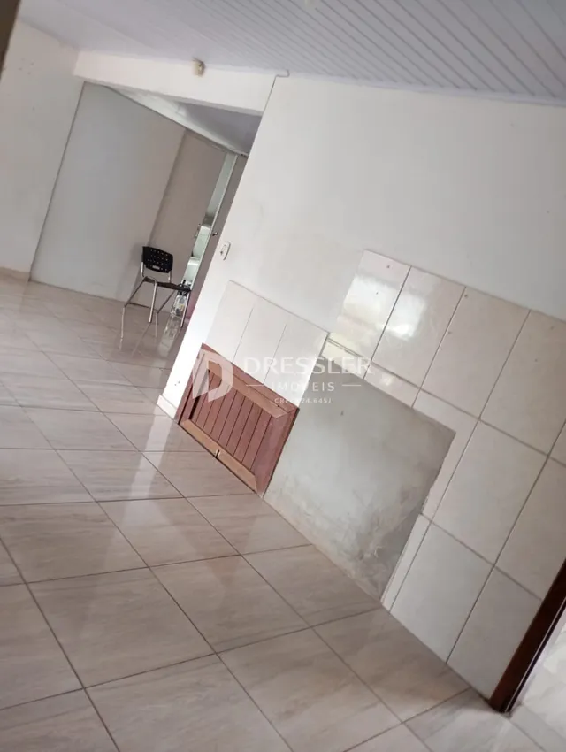 Hall de entrada com piso de cerâmica clara e paredes brancas.