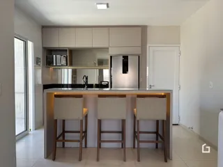 Foto de uma cozinha moderna com bancada e banquetas em um imóvel no Brasil.