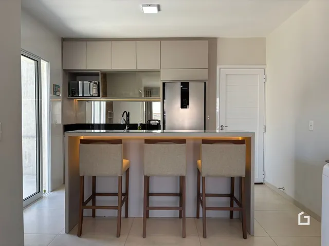 Foto de uma cozinha moderna com bancada e banquetas em um imóvel no Brasil.