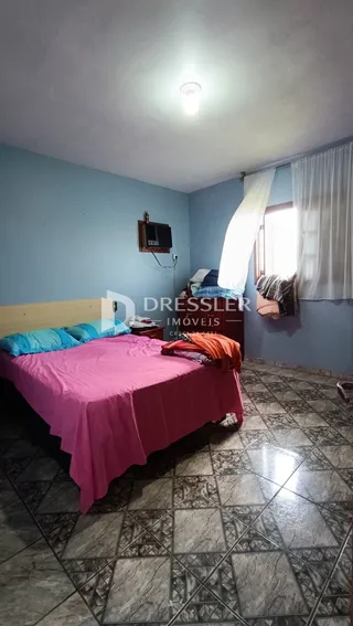 Quarto com paredes azuis e piso de cerâmica.