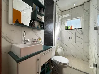 Foto de um banheiro moderno com revestimento de mármore e box de vidro.