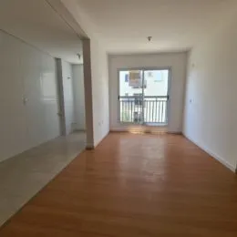 Vista de um corredor com piso de madeira clara.