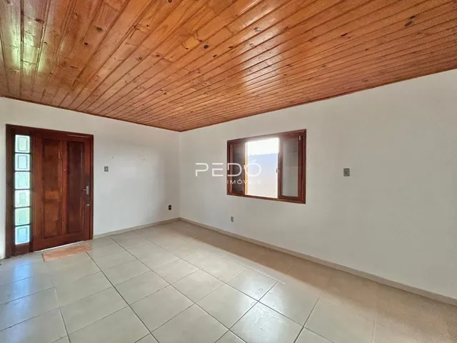 Ambiente interno de uma sala com piso de cerâmica e teto de madeira.