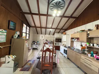 Interior da cozinha com armários e piso de cerâmica em uma residência.