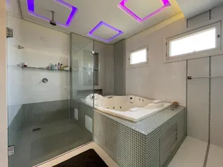 Banheiro com banheira e box de vidro em um imóvel.