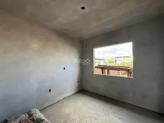 Vista interna de um cômodo com paredes brancas e piso de concreto.
