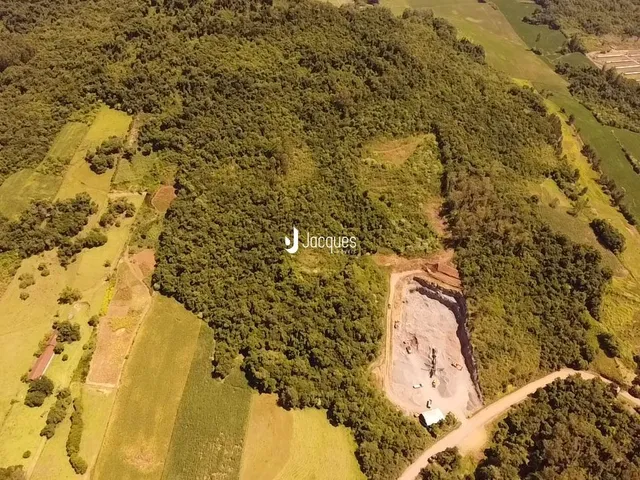 Vista aérea de uma área rural com vegetação densa e campos abertos.