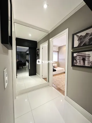 Hall de entrada com piso branco e espelho refletindo o ambiente interno.