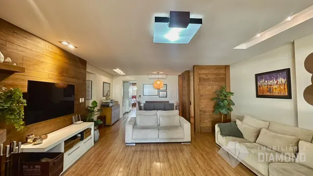 Sala de estar com piso de madeira e sofá branco.