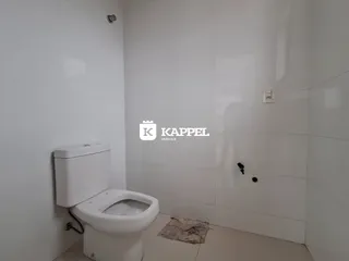 Foto de um banheiro com paredes brancas e um vaso sanitário branco.