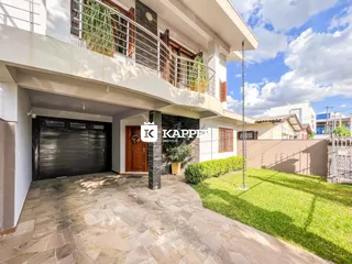 Fachada de uma casa residencial em Lajeado, Brasil, mostrando a garagem e o jardim frontal.