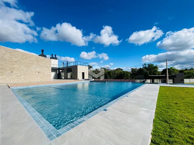 Vista externa de uma piscina e jardim em uma propriedade.