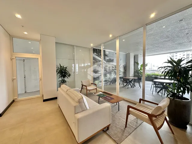 Sala de estar moderna com grandes portas de vidro que dão acesso a uma área externa.