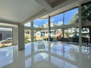 Sala ampla com grandes janelas que proporcionam uma vista externa.