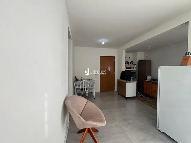 Sala de estar com paredes brancas e piso de cerâmica clara.