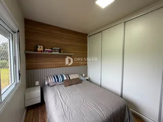 Quarto com parede de madeira e armários brancos em um imóvel no Brasil.