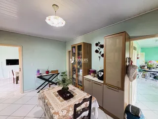 Ambiente interno de uma sala com piso de cerâmica e paredes verde-água.