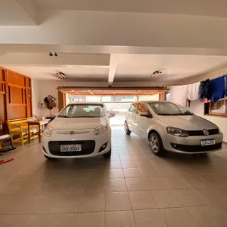 Interior de uma garagem ou área comum com dois carros estacionados.