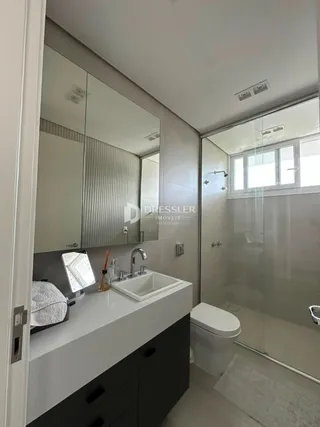 Foto de um banheiro moderno com bancada e box de vidro.