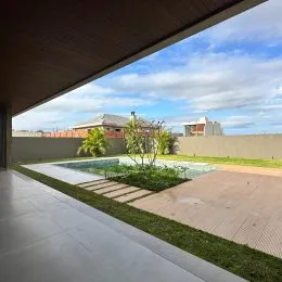 Uma vista externa mostrando um pátio com gramado e vegetação.