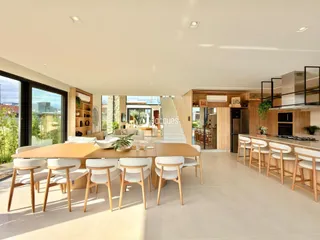Ambiente moderno de sala de jantar com grandes janelas e vista para o exterior.