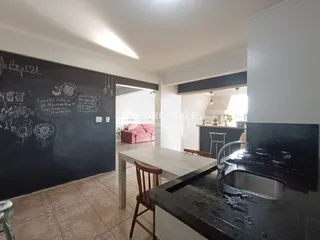 Interior de uma sala com parede de quadro-negro e piso de cerâmica.