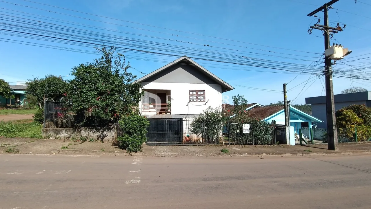 Fachada de uma residência em Lajeado, Brasil, com cerca e vegetação ao redor.