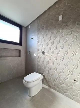 Foto de um ambiente interno de banheiro com parede texturizada.